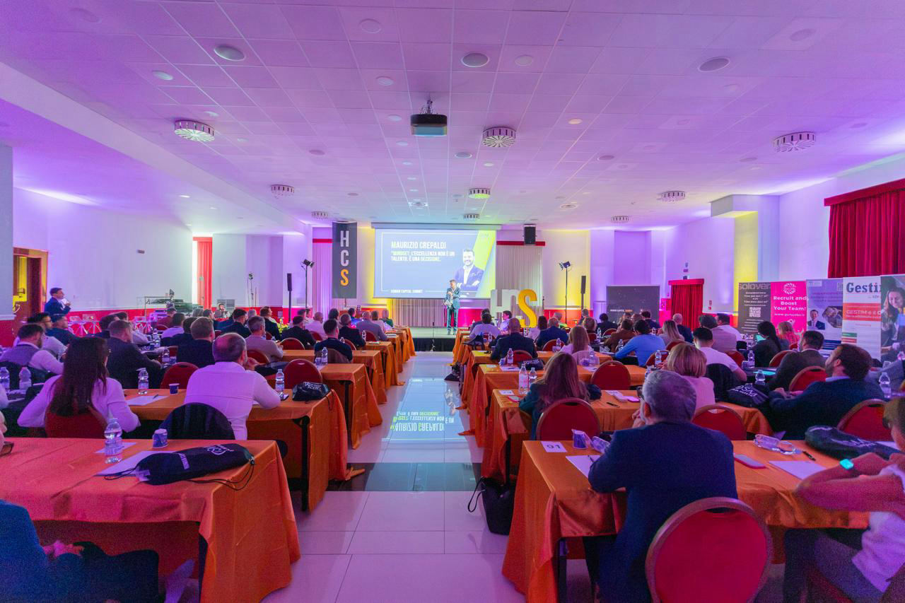 Sala di un evento con il pubblico ai tavoli